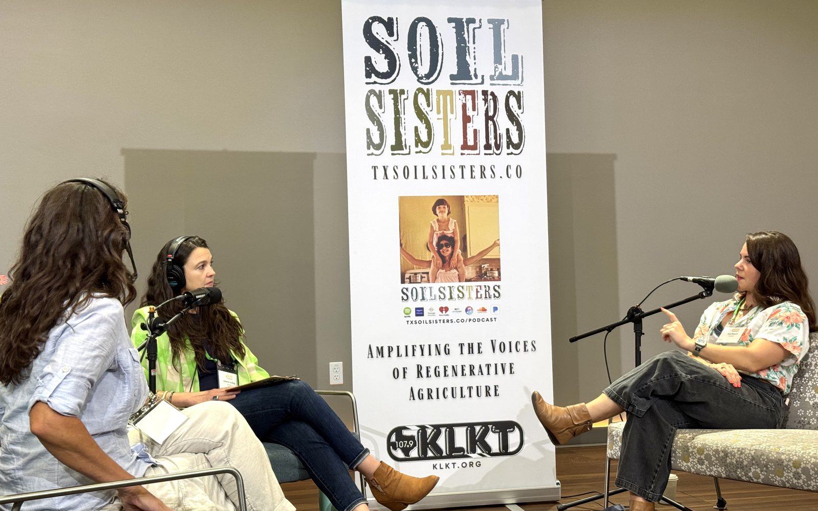 Jessi recording a live podcast panel in front of a Soil Sisters banner