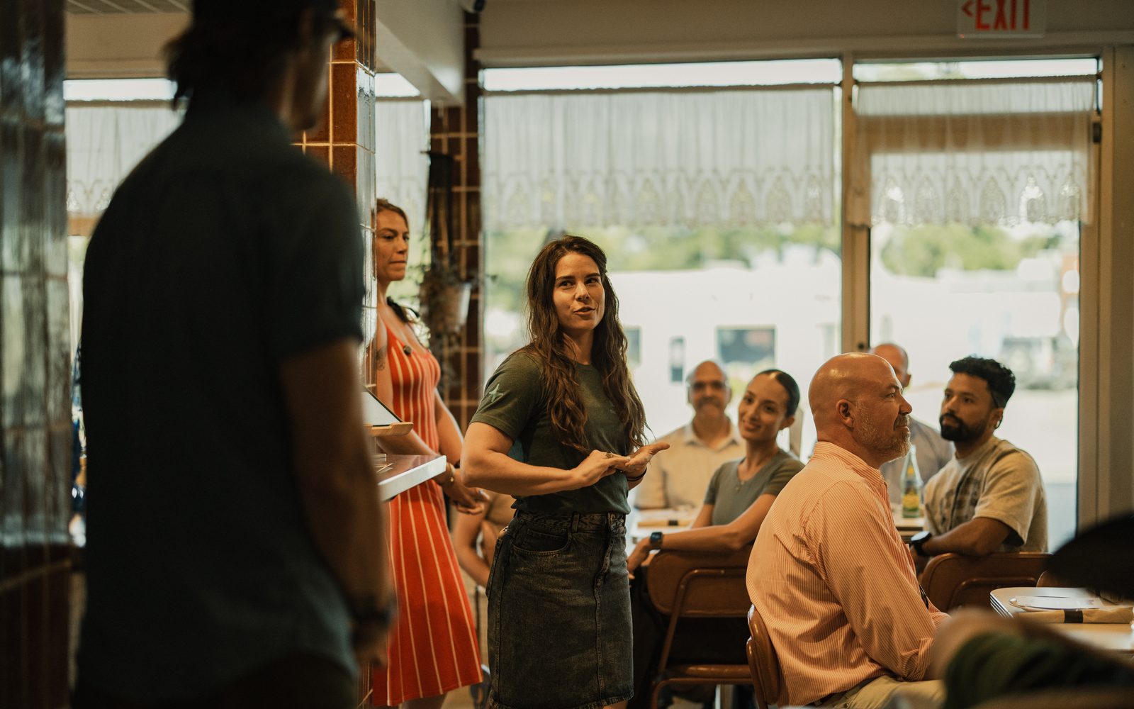 Jessi standing mid-room facilitating a seated group of farmers
